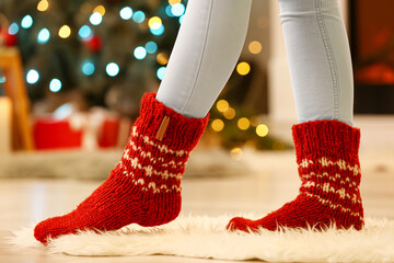 Woman in warm socks at home on Christmas eve