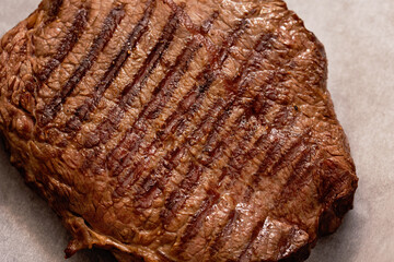 Close-up grilled meat of beef steak grilled in cast-iron ribbed fry pan Delicious juicy meat steak cooking on grill on white background, top view