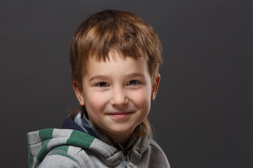 Portrait of a cute little boy on a dark background.