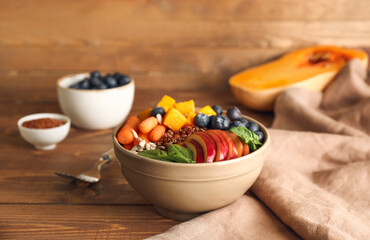 Healthy quinoa bowl with fruits and vegetables on table