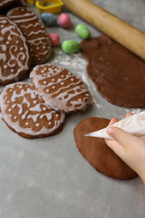 Girl decorates homemade gingerbread for Easter