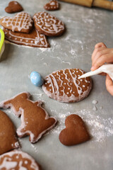 Girl decorates homemade gingerbread for Easter
