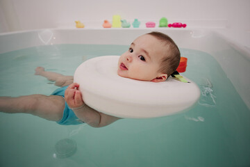 Baby enjoying in the jacuzzi. Spa for babies. Hydrotherapy session for children. Baby swimming