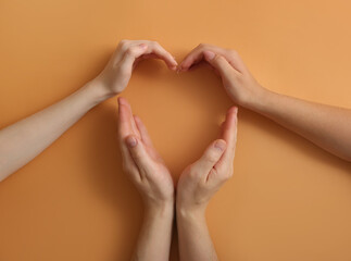 Human hands making heart on color background. Polyamory concept