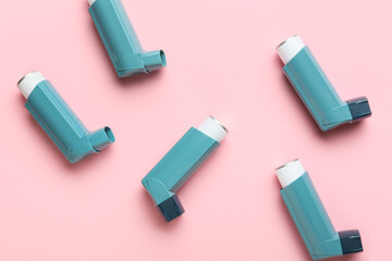 Modern asthma inhalers on color background
