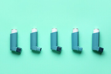 Modern asthma inhalers on green background