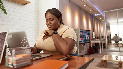 Fototapeta na wymiar Black woman watching on laptop during working