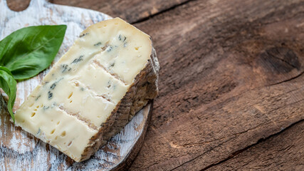 French cheeses blue cheese dorblu, gorgonzola, roquefort on wooden table. vertical image. top view. place for text