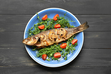 Plate with delicious sea bass fish, microgreens and tomatoes on dark wooden background - obrazy, fototapety, plakaty