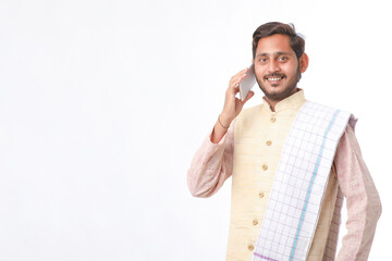 Young indian farmer talking on mobile phone over white background.