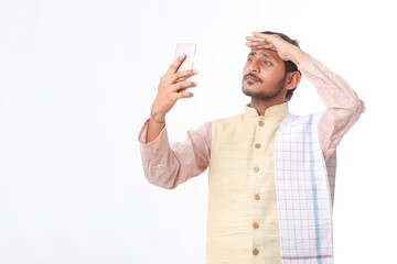 Young indian farmer using smartphone on white background.