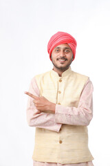 Young indian man in traditional wear and giving expression on white background.
