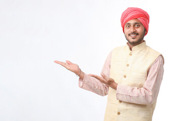 Young indian man in traditional wear and giving expression on white background.