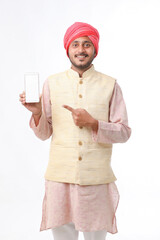 Young indian man showing smartphone and giving expression on white background.