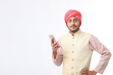 Young indian farmer using smartphone on white background.