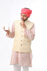 Young indian man showing smartphone and giving expression on white background.