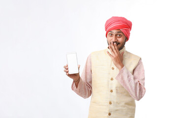 Young indian man showing smartphone and giving expression on white background.