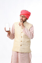 Young indian man showing smartphone and giving expression on white background.