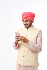 Young indian farmer using smartphone on white background.