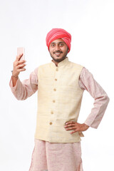 Young indian farmer using smartphone on white background.