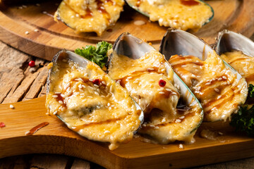 Mussels baked with cheese, teriyaki sauce and sesame seeds. Close-up.