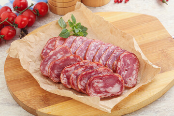 Sliced salami sausages over board