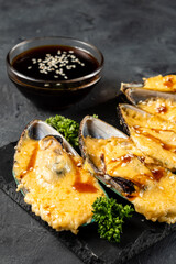 Appetizer of baked mussels with cheese, vertical photo, selective focus.