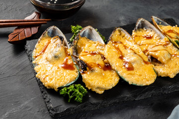 Delicious baked mussels with cheese close-up. Selective focus.