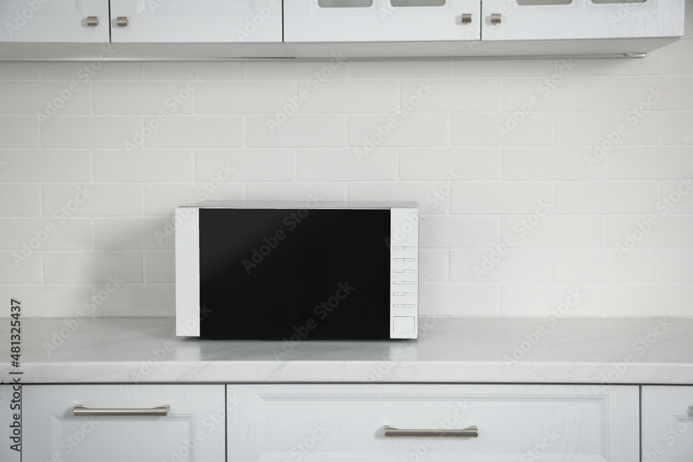 Poster Modern microwave oven on countertop in kitchen