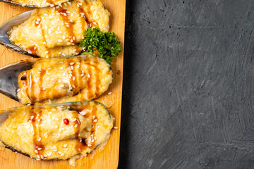 Baked mussels in a shell with cheese, top view, free space.