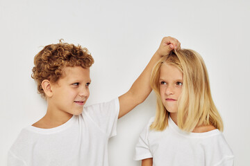 Photo of two children in white T-shirts are standing next to childhood unaltered