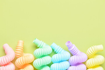 Different colorful Pop Tubes on green background