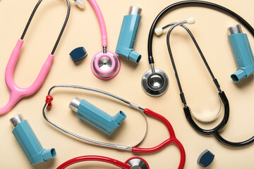 Asthma inhalers and stethoscopes on beige background