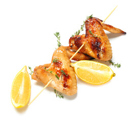 Grilled chicken wings skewer with lemon and thyme on white background