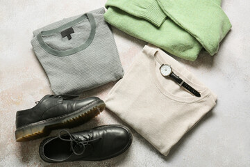 Stylish male sweaters, wristwatch and shoes on light background