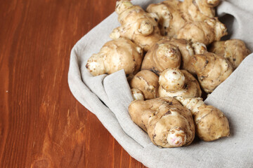 Raw Jerusalem artichoke on a gray linen cotton napkin. Jerusalem artichoke solar root, earthen pear
