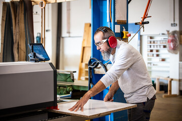 male craftman is working with a edge banding machine