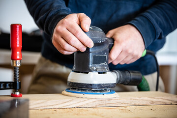 a male craftsman uses an electric grinder