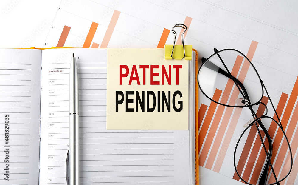 Aufkleber text patent pending on sticker on the notepad on diagram background