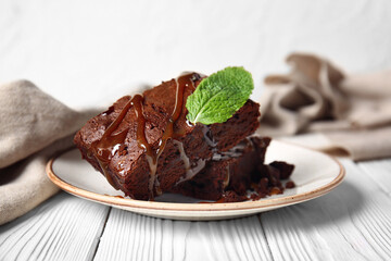Plate with pieces of tasty chocolate brownie on table