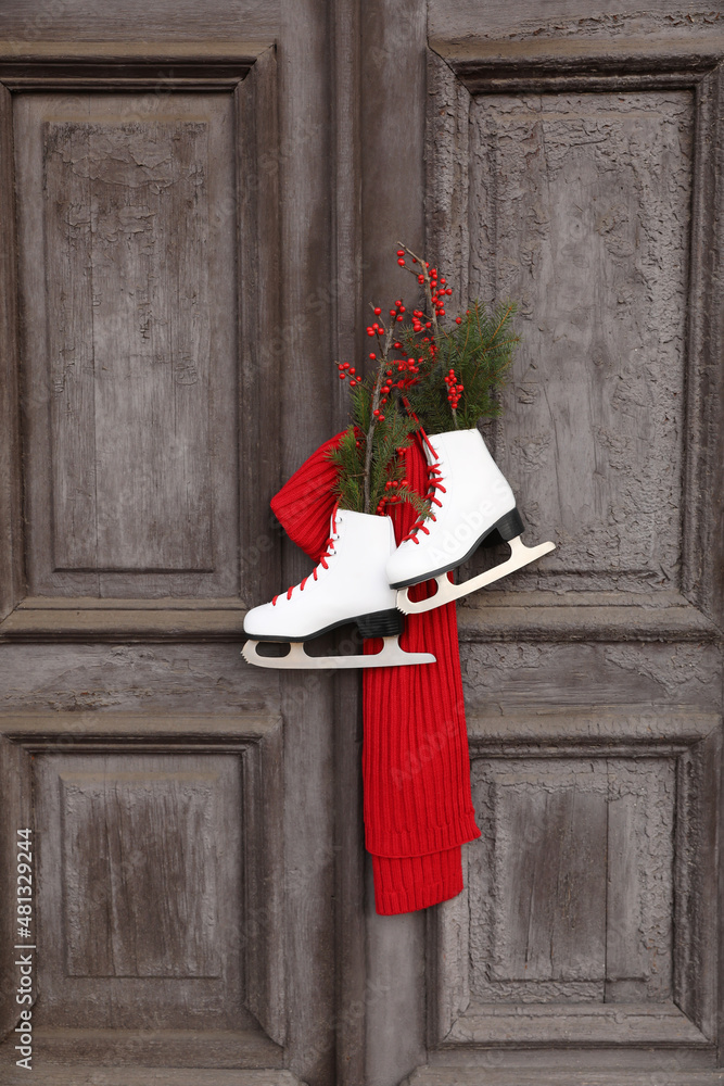 Sticker Pair of ice skates with Christmas decor hanging on old wooden door