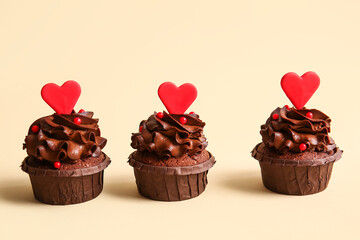Tasty chocolate cupcakes for Valentine's day on beige background