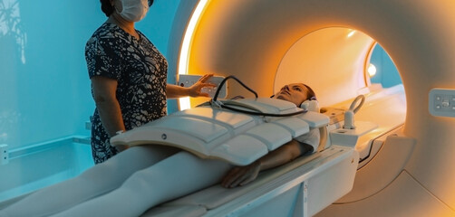 Doctor or nurse and patient with tomography CT or MRI Scan in hospital. Interior of radiography...