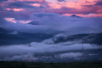 Pink dawn and fog against the backdrop of the mountains