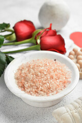 Bowl with sea salt for Valentine's Day celebration on light background, closeup