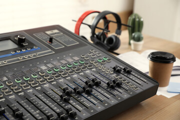 Professional mixing console on wooden table in modern radio studio, closeup