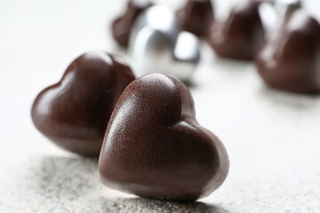 Tasty heart-shaped candies on light background, closeup