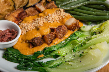 Close view of a Filipino dish, Crispy pork belly kare-kare with vegetables