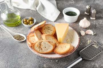 Plate of tasty croutons with cheese on grey background