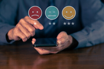 Customer service satisfaction rating icon with hand holding smartphone.